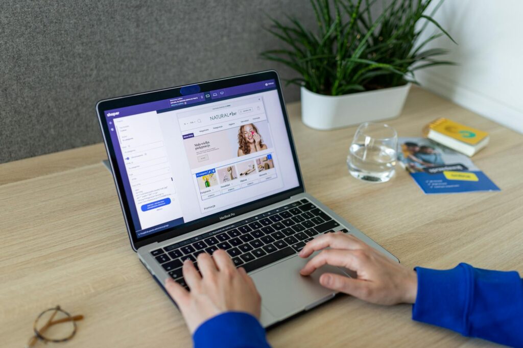 dlonie wpisujace tekst na klawiaturze laptopa z otwartym panelem sklepu internetowego shoper